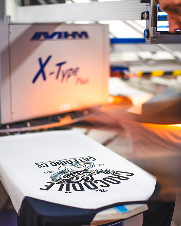 Screen printing staff uniforms on an automatic screen printing press
