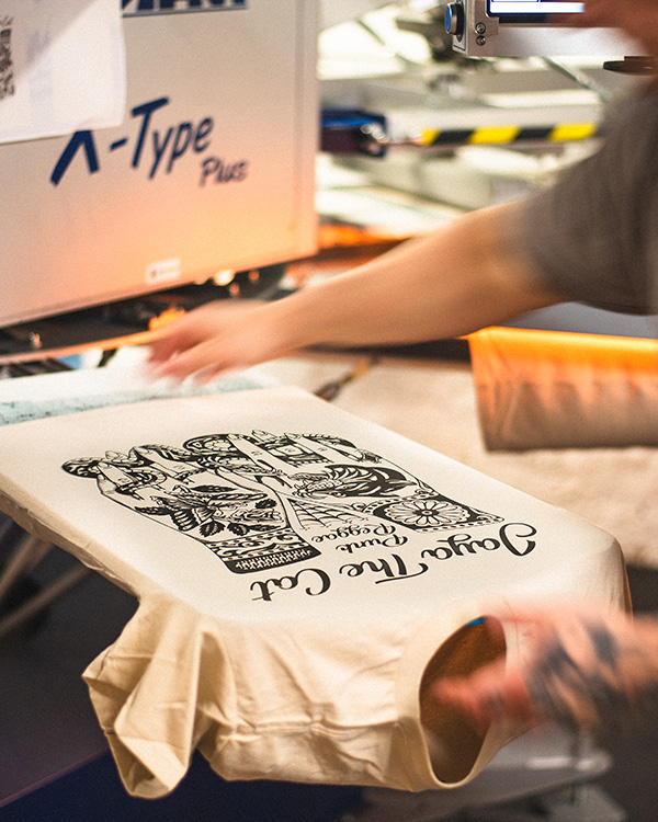 Band tour merchandise being screen printed on an automatic press in a UK print studio